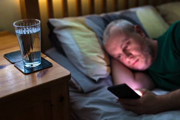 새벽에 휴대폰을 들여다보며 잠을 못 이루는 모습