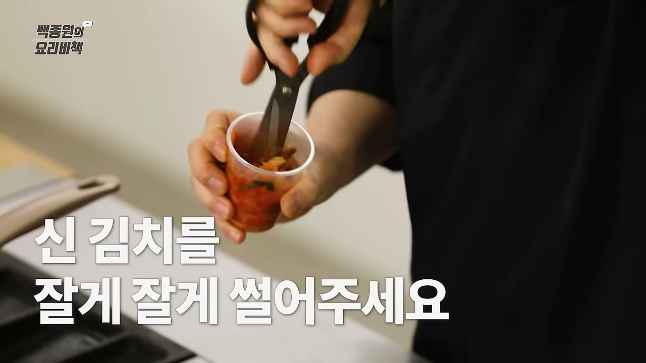 신김치를 가위로 자르는 장면