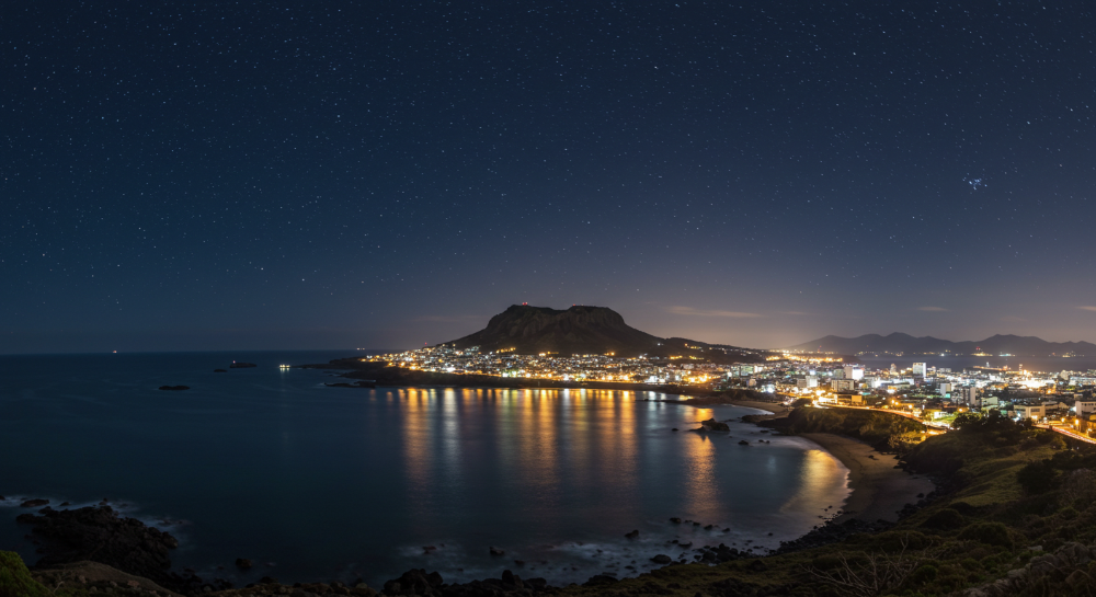 제주도 밤바다와 해안가 야경이 조화롭게 펼쳐진 모습