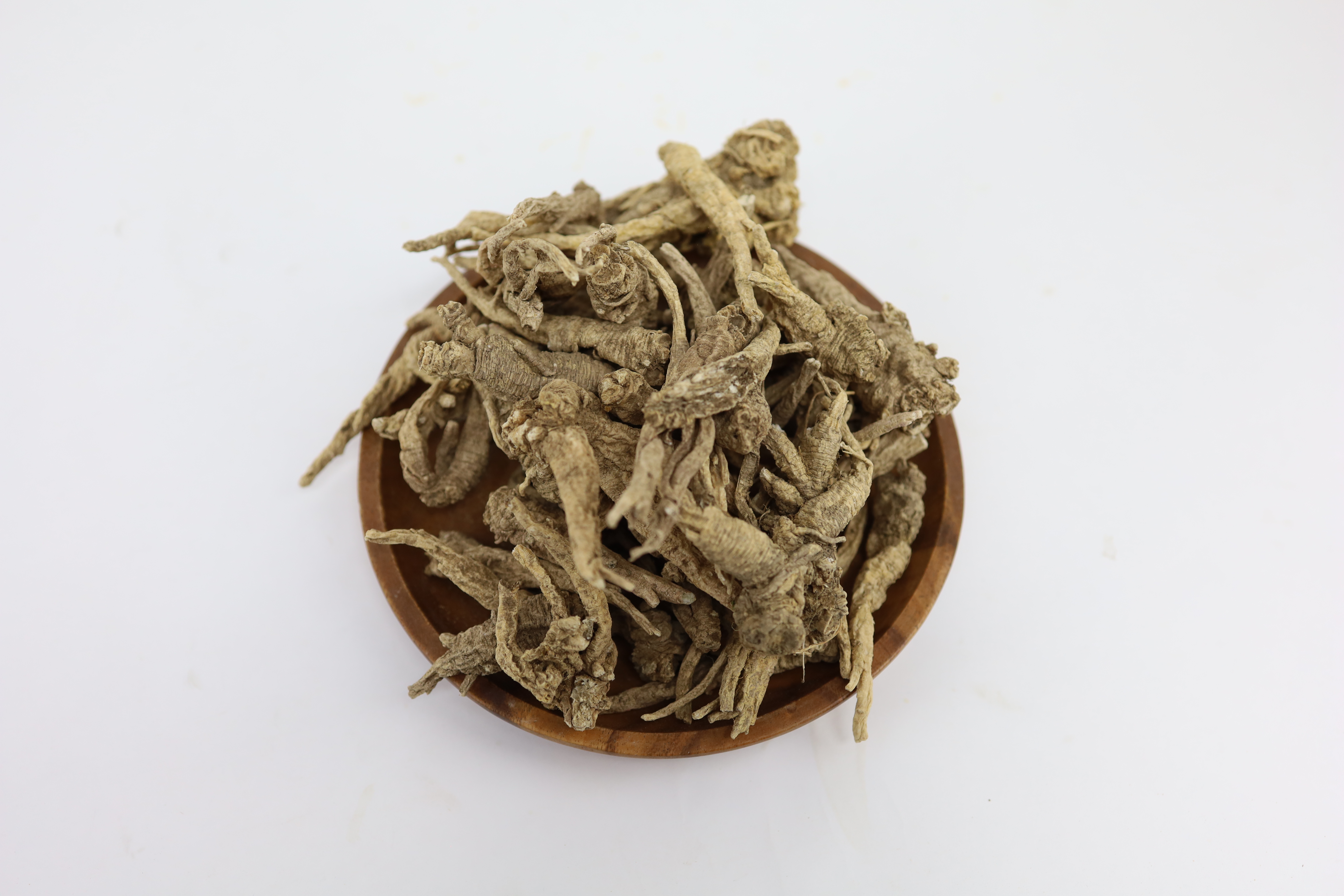 야생에서 채취를 한 잔대뿌리(사삼)을 깨끗이 세척을 해서 하얀 바닥 위에 있는&#44; 동그란 나무 그릇에 가득 담아 놓은 사진