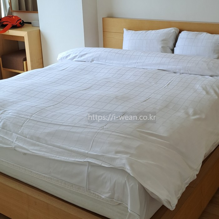 스위트 디럭스 룸 안에 침대가 놓여 있습니다.