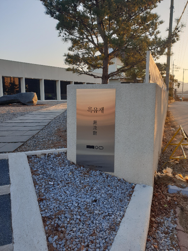 입구 담에 부착되어 있는 메탈 소재 간판