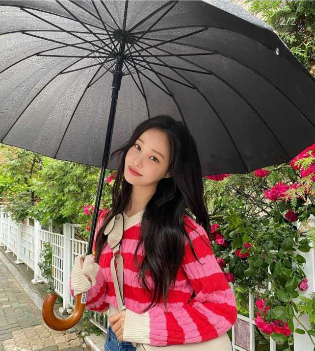 비오는날 우산을 쓰고 사진을 찍고 있는 연우의 모습