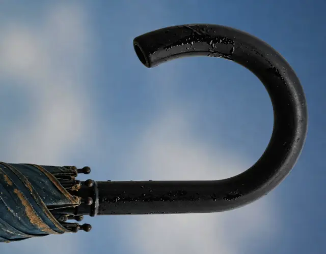 푸른 하늘 배경의 끈적이는 우산 손잡이 이미지