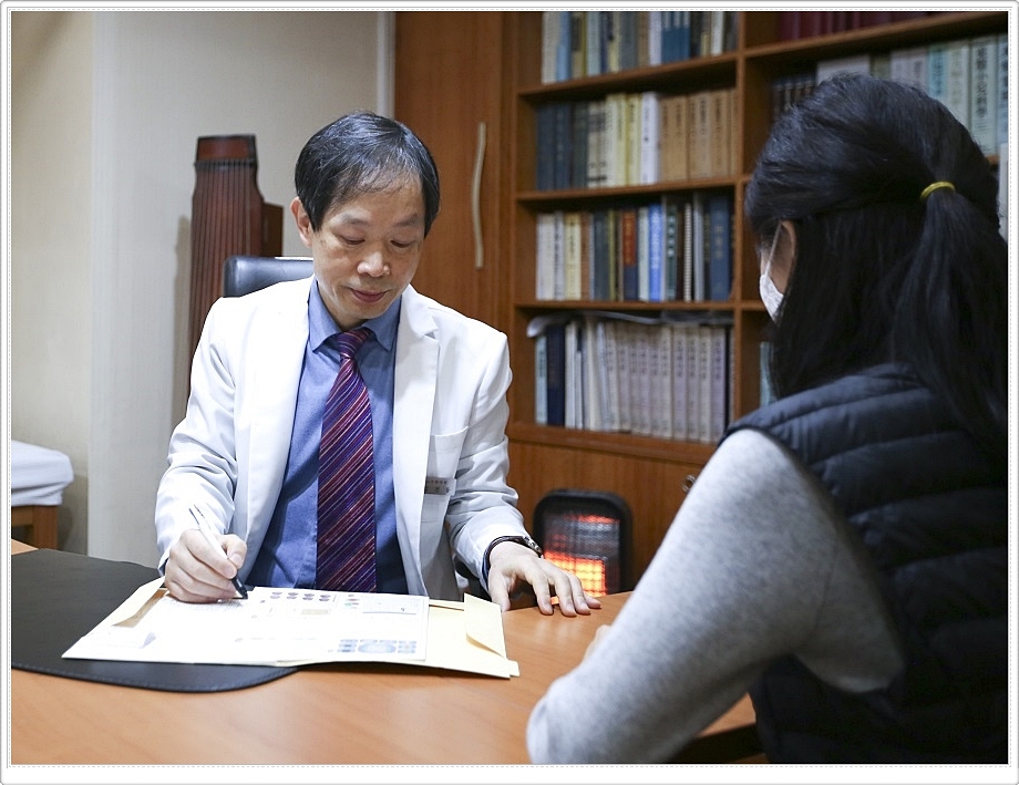 차트를 보며 진료 상담 중인 한의사와 환자의 모습