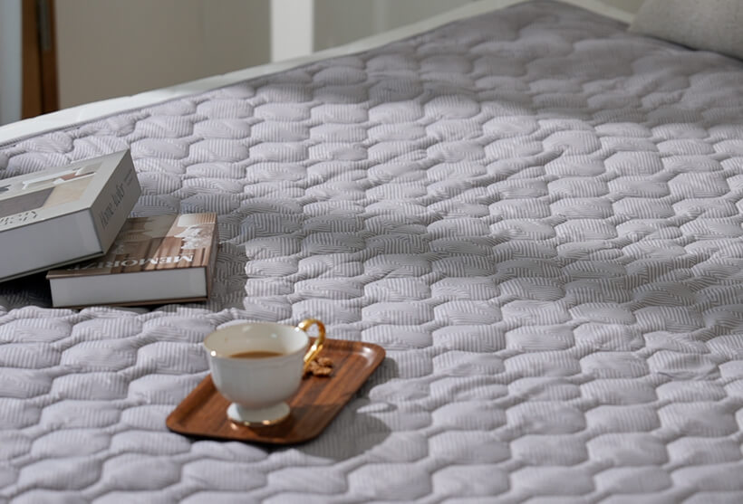 침대 위에 놓인 매트와 책, 그리고 커피잔