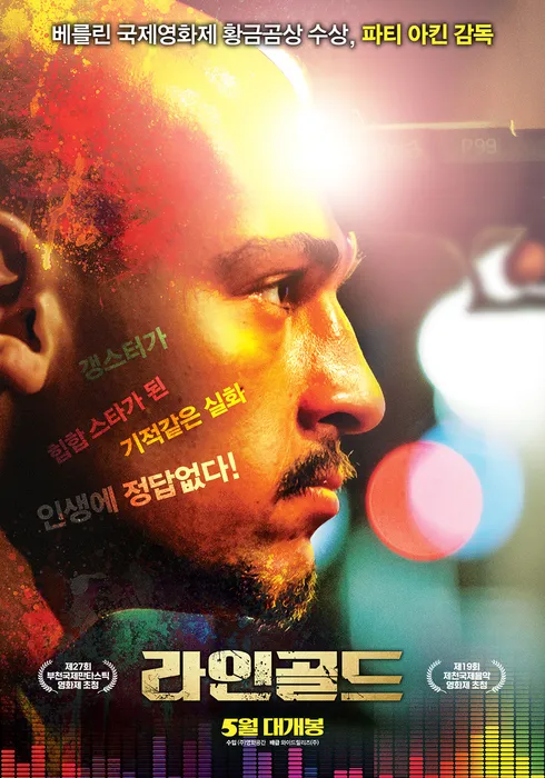 옆을 바라보는 주인공 래퍼의 얼굴 클로즈업, 황금빛 배경이 강조된 포스터