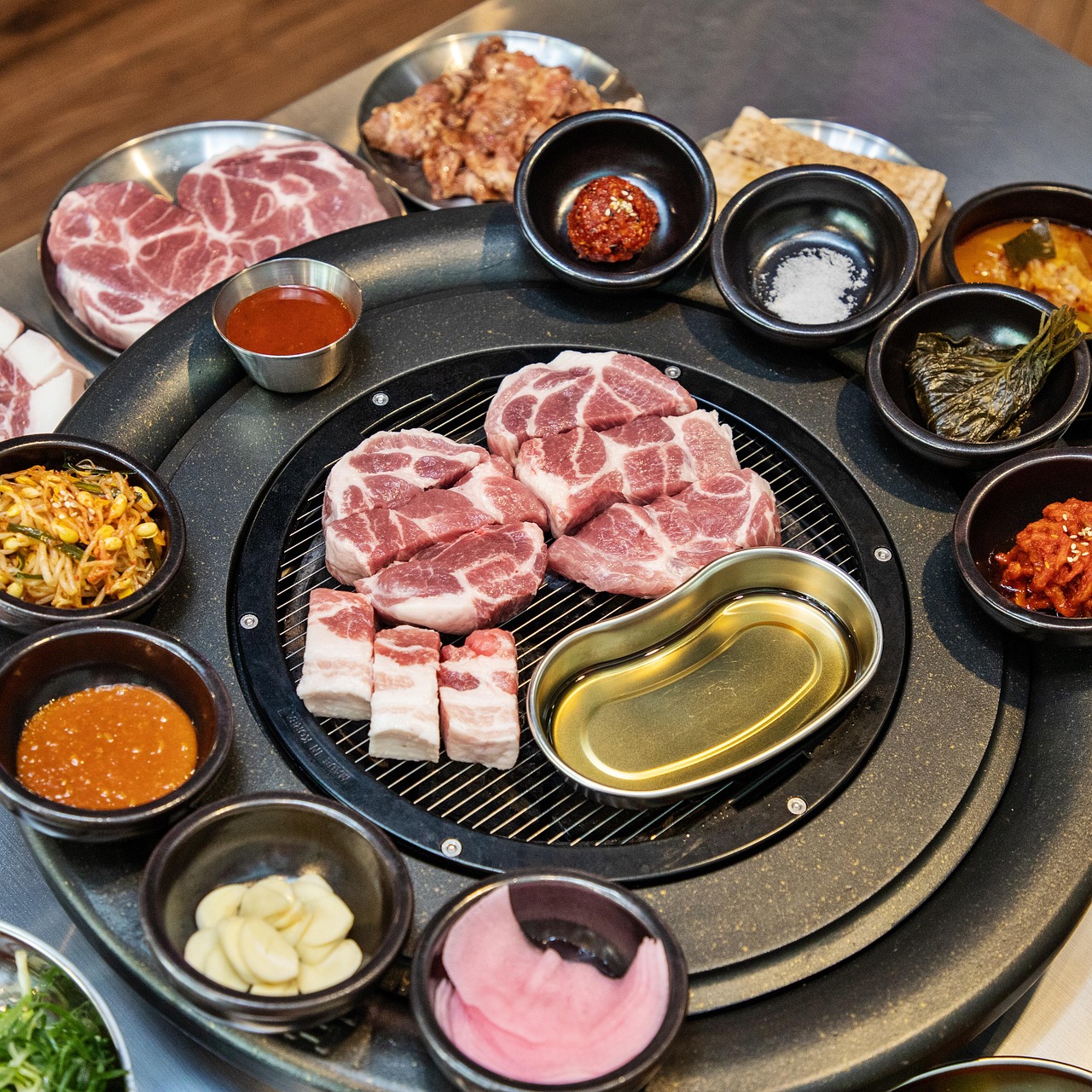 Charcoal-grilled pork slices sizzling on a traditional Korean BBQ grill with a smoky aroma rising.