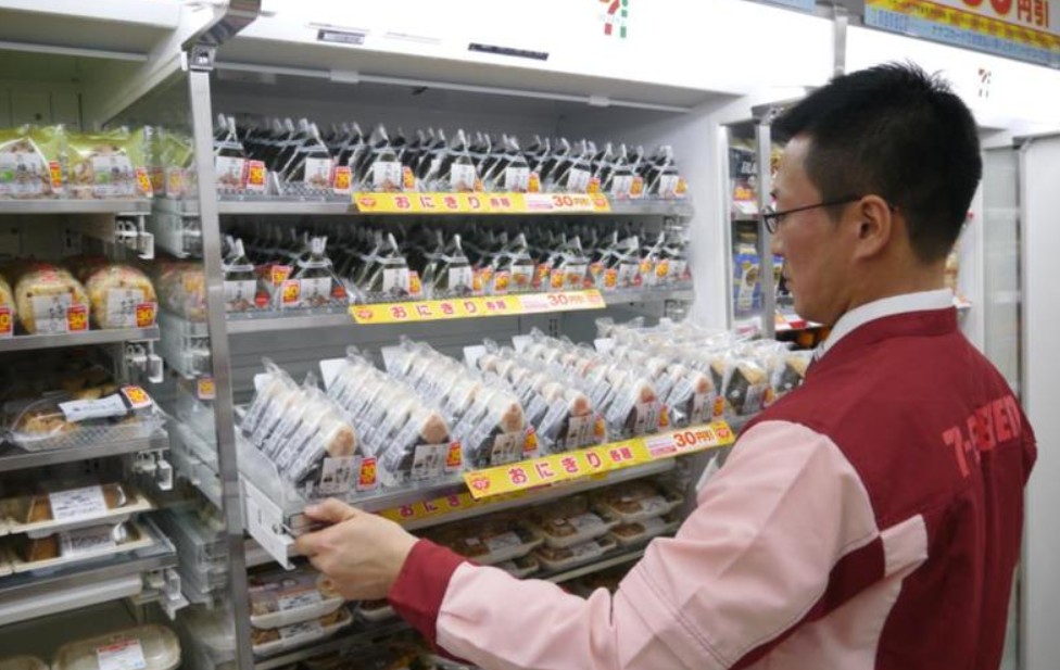 편의점에 물건을 진열하고 있는 남자 직원