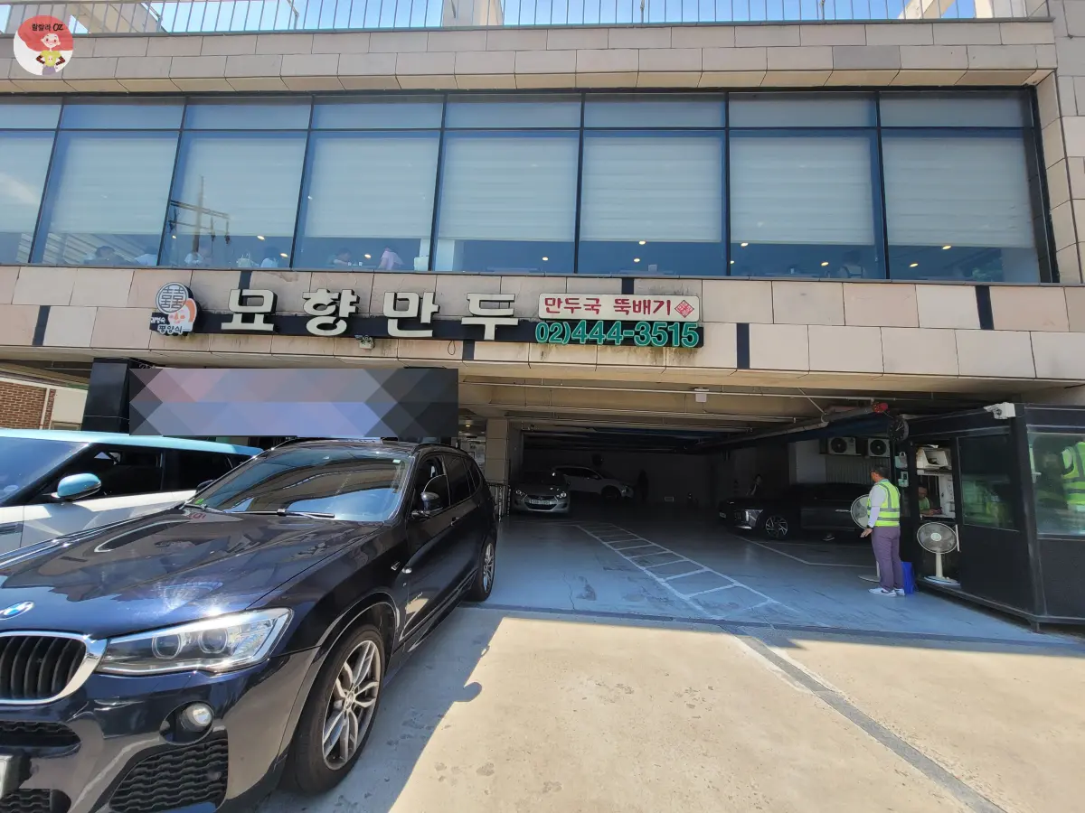 경기-구리시-묘향만두-외관-건물앞에-주차된-차옆으로-전용주차장과-주차요원이-보임