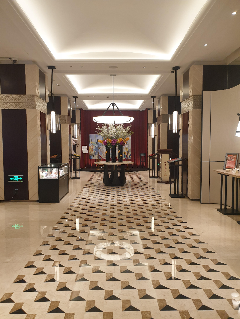 저 멀리 붉은 커튼이 있고 그 앞에는 꽃으로 장식된 로비