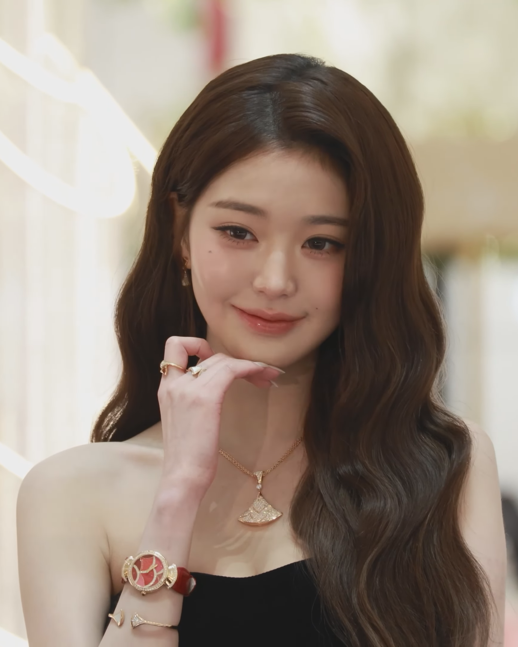 Jang Wonyoung with long wavy hair, defined upper lashes and glossy rose lips at a December 2025 event.