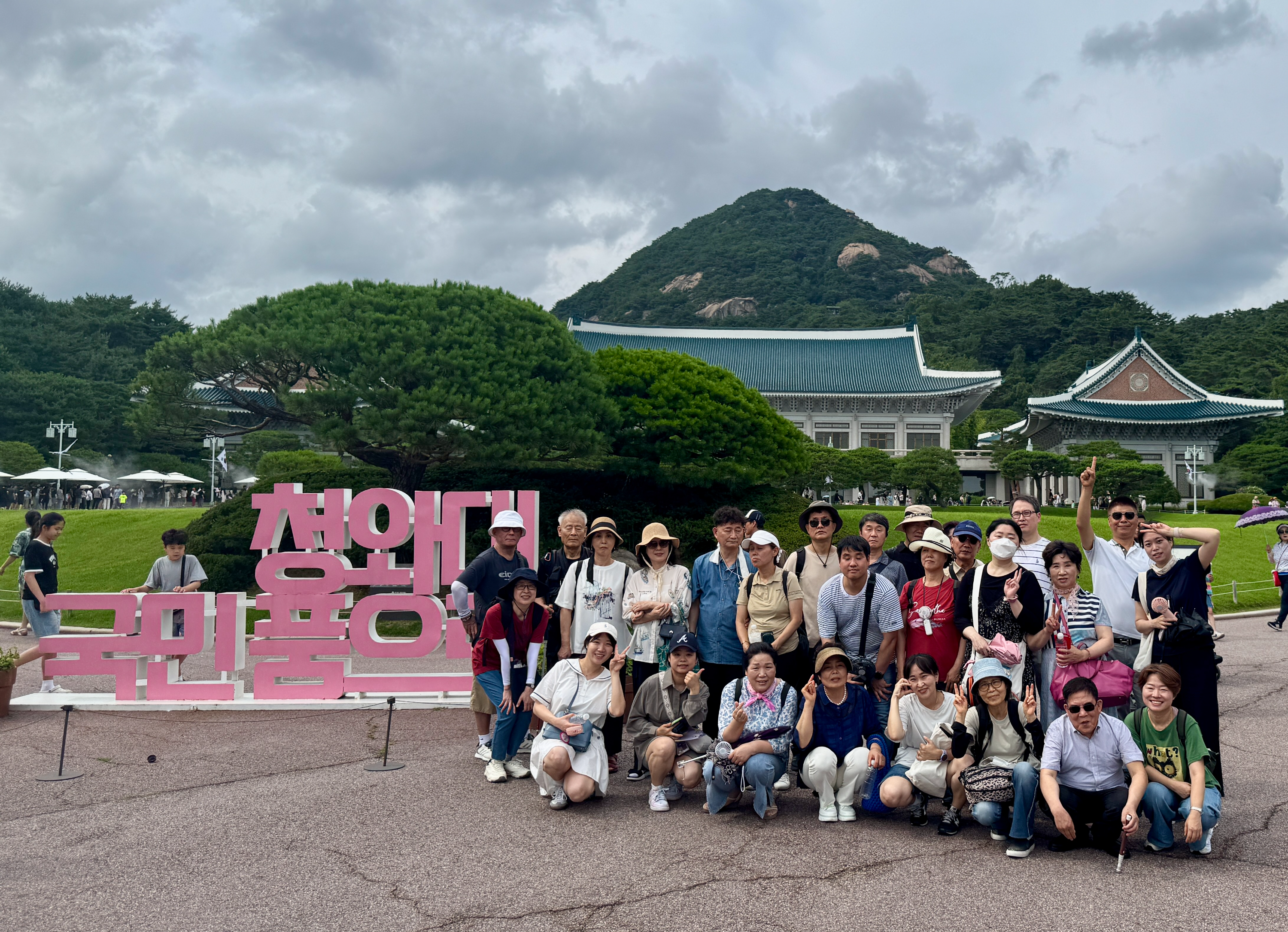 청와대 본관을 뒤로 두고 찍은 단체사진.
왼쪽에 청와대 국민품으로 라는 문구가 쓰인 간판이 있고 오른쪽에 지회원들이 함께 자리하고 있다.
