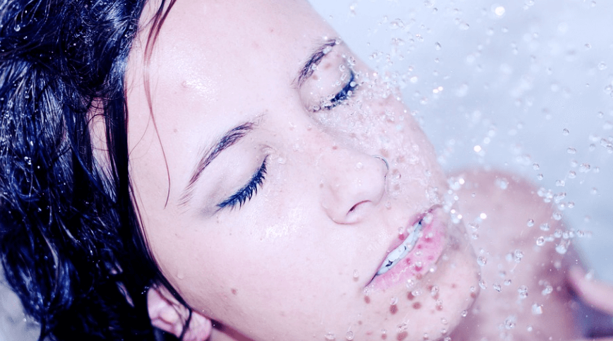 각질이 생기는 이유가 되는 수분 부족으로 샤워를 하고 있는 여자