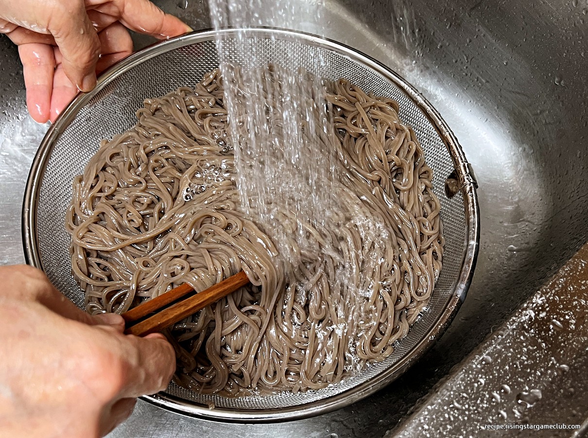 판모밀국수에 들어갈 삶아진 메밀 생면을 흐르는 물에 식히는 사진