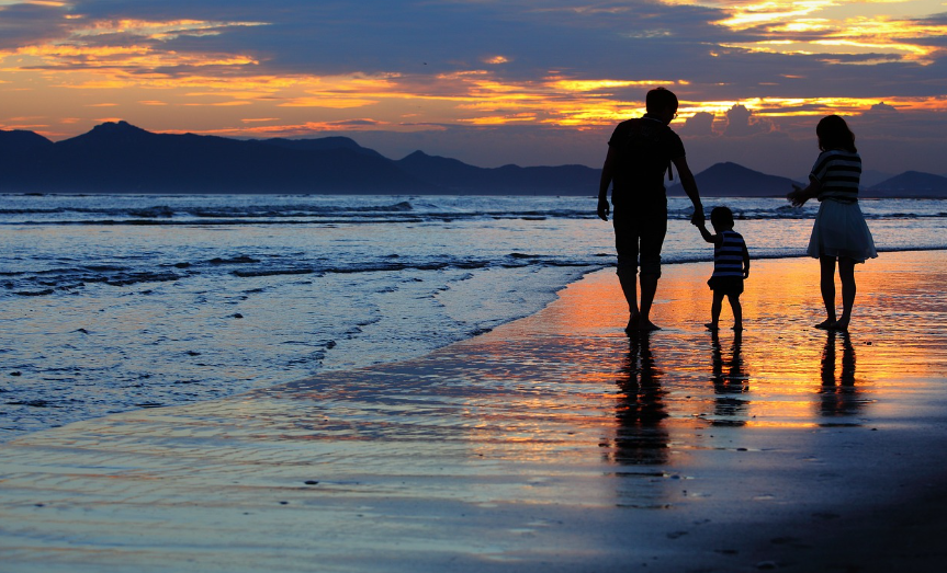 3명의 가족이 부산 바닷가를 걷는 사진