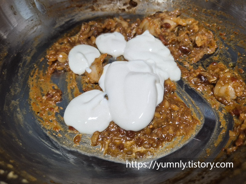 Pouring heavy cream and pasta water into the pan to make the sauce