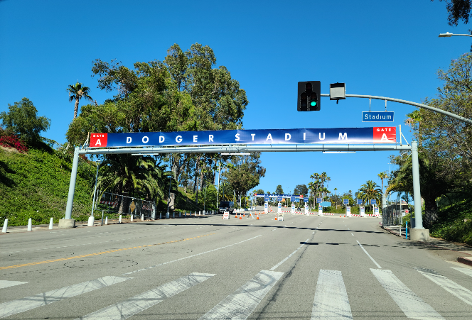 다저 스타디움으로 들어가는 길. 게이트 A. 6차선 정도 되는 큰 길 위에 게이트가 만들어져 있다. 게이트 위에는 파란 배경 위에 하얀 글씨로 DODGER STADIUM이라고 가로로 크게 적혀 있다.