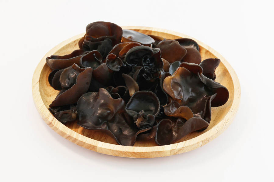 야생에서 채취를 한 목이버섯을 깨끗이 세척을 한 후에 잘 손질을 한 것을 하얀 바닥 위에 나무로 만든 동그란 그릇을 놓고 그 속에 가득 담아 놓고 찍은 사진