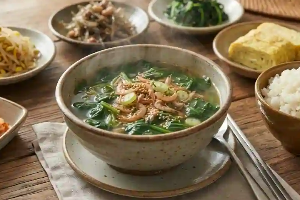 식탁 위에 건새우가 들어 있는 시금칫국과 밥, 반찬이 올려져 있음.