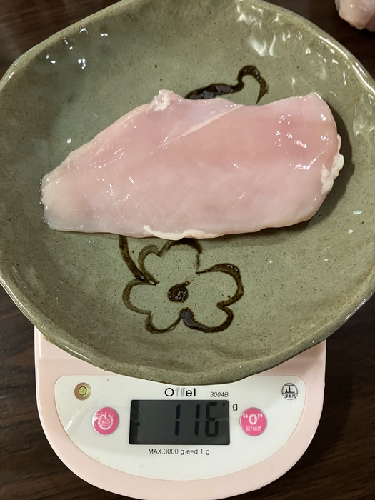 접시에 올린 생닭가슴살을 전자저울로 측정한 모습, 중량 116g