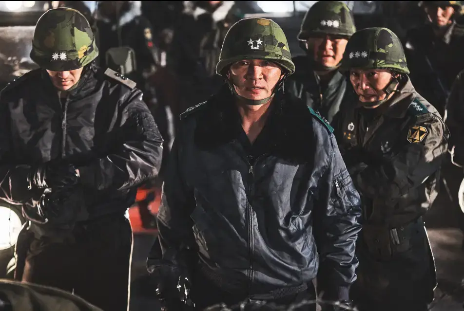 군인 잠바를 입고 군인모를 쓰며 앞을 화난듯 쳐다보는 전두광