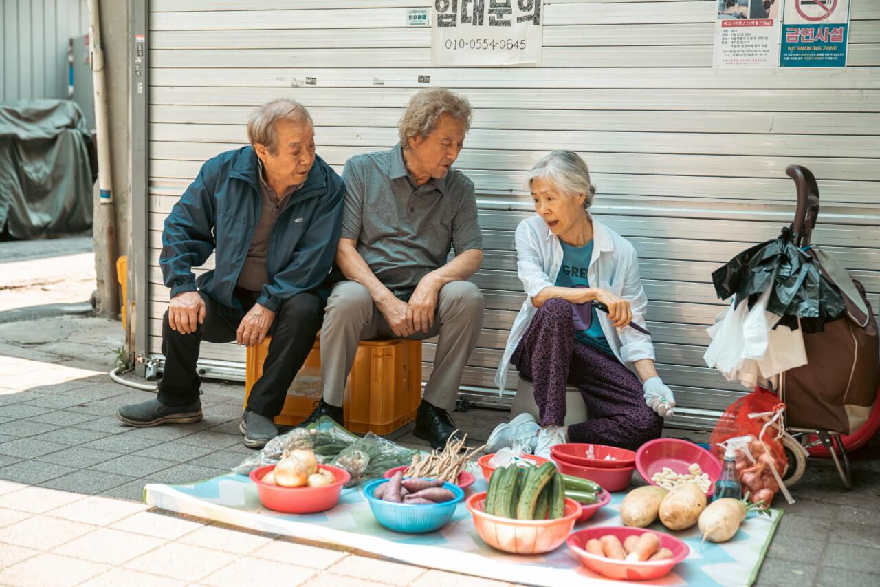 화진의 야채 가판대 앞에 모여 있는 세 명의 노인