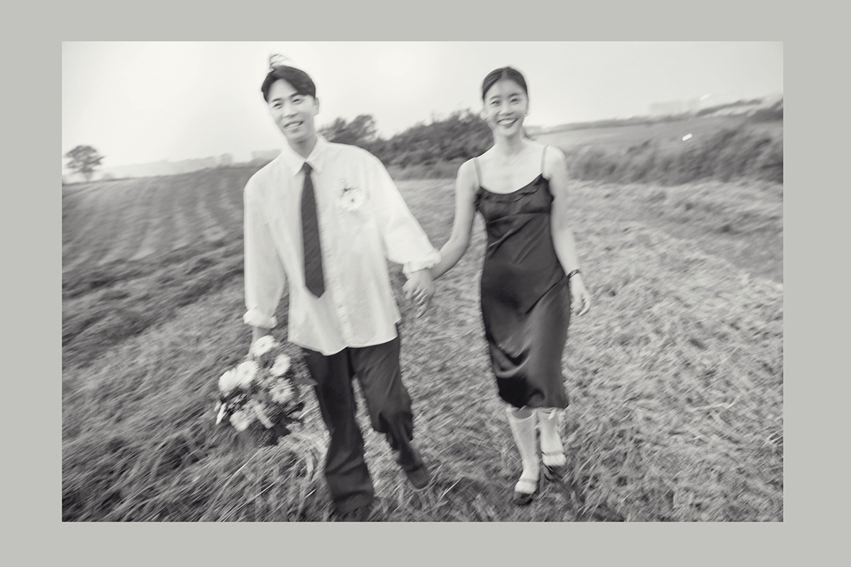 흑백사진. 서로 손을 잡고 미소를 짓고 있다.