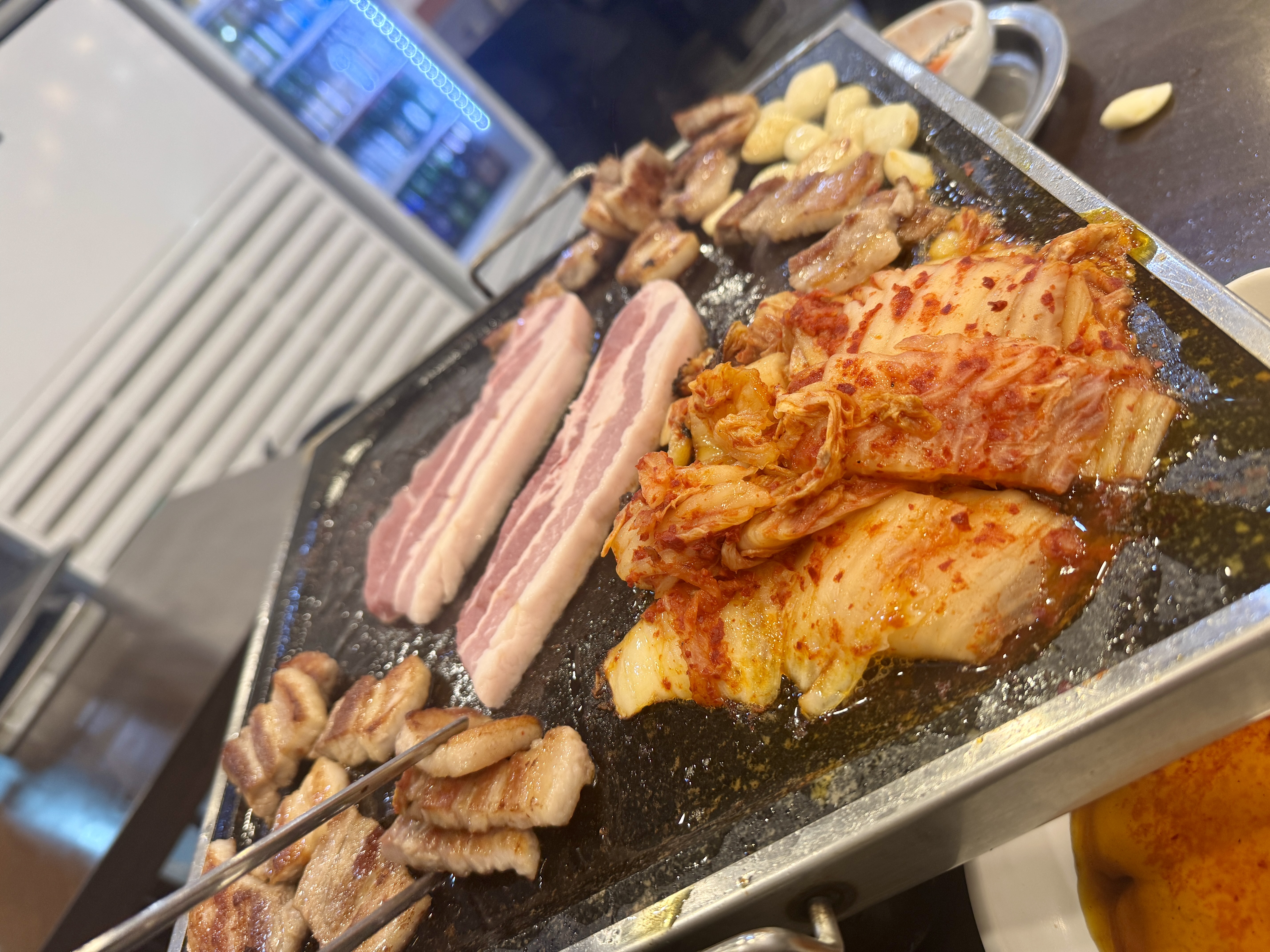 솔밭식당에서 삼겹살 추가 주문한 모습&amp;#44; 불판 위로 두툼한 고기가 올려져 있음.