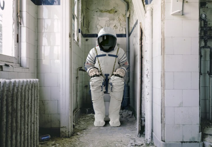 우주복을-입고-변기에-앉아있는-사람