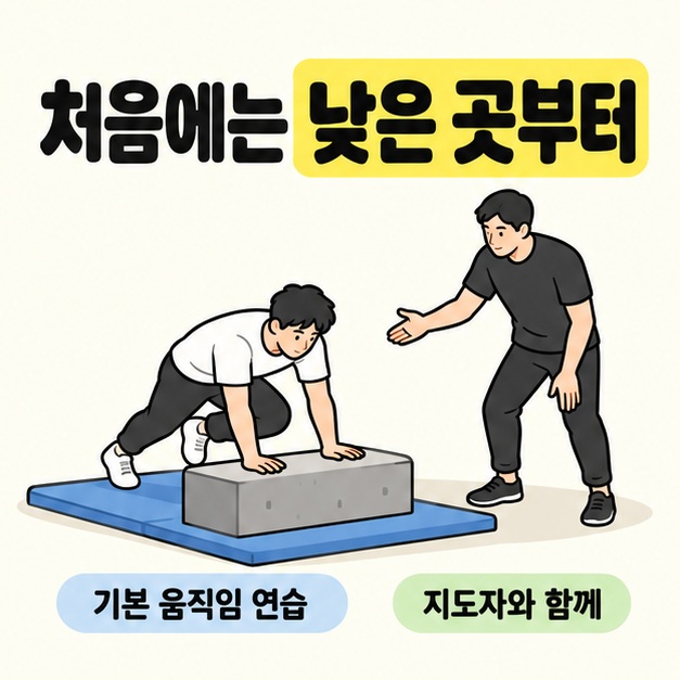 바닥 매트 위의 낮은 블록에서 초보자가 기본 움직임을 연습하고 옆의 지도자가 안내하는 장면