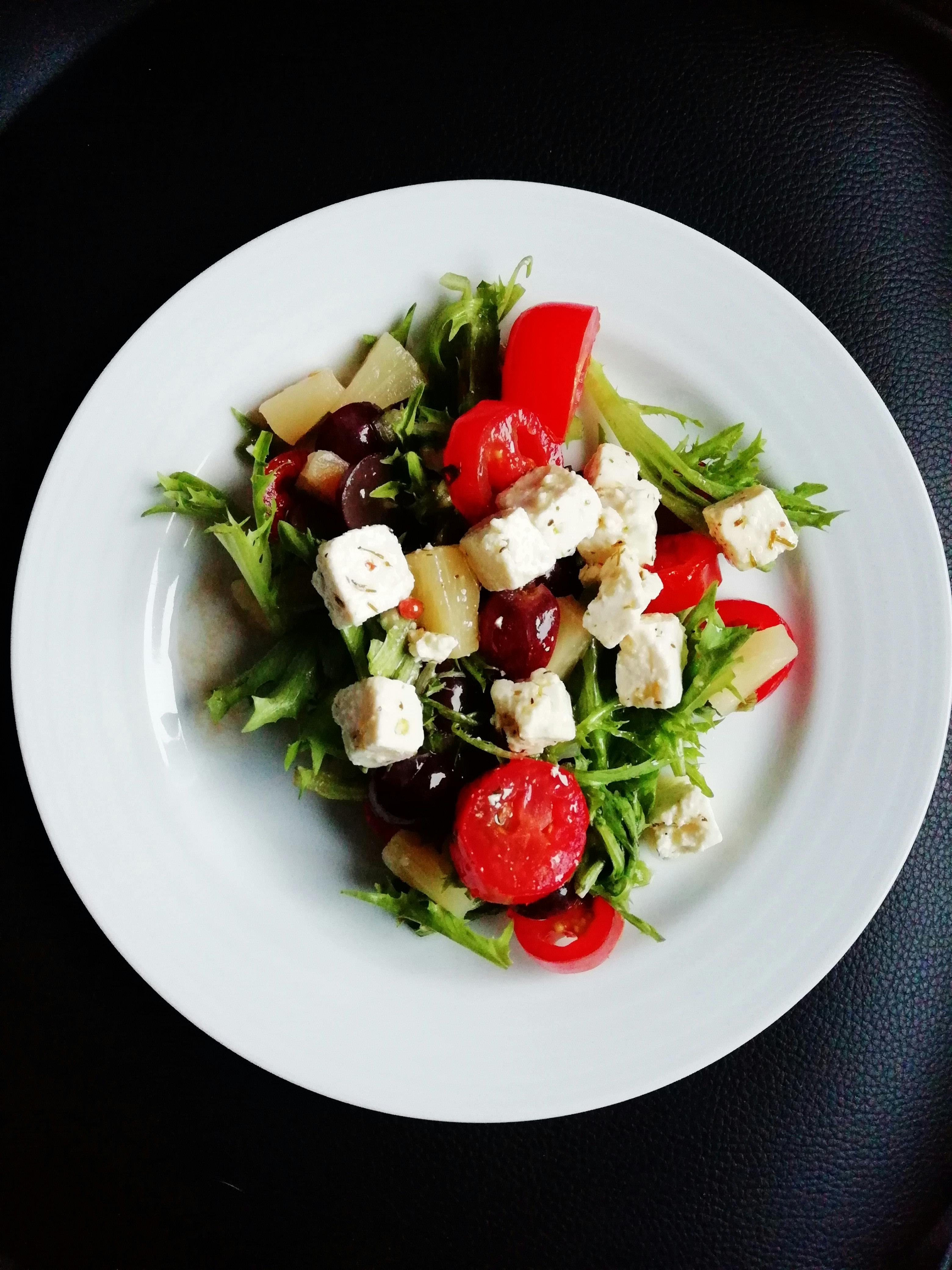a Greek salad with tomatoes, cucumbers, feta cheese, and olives.