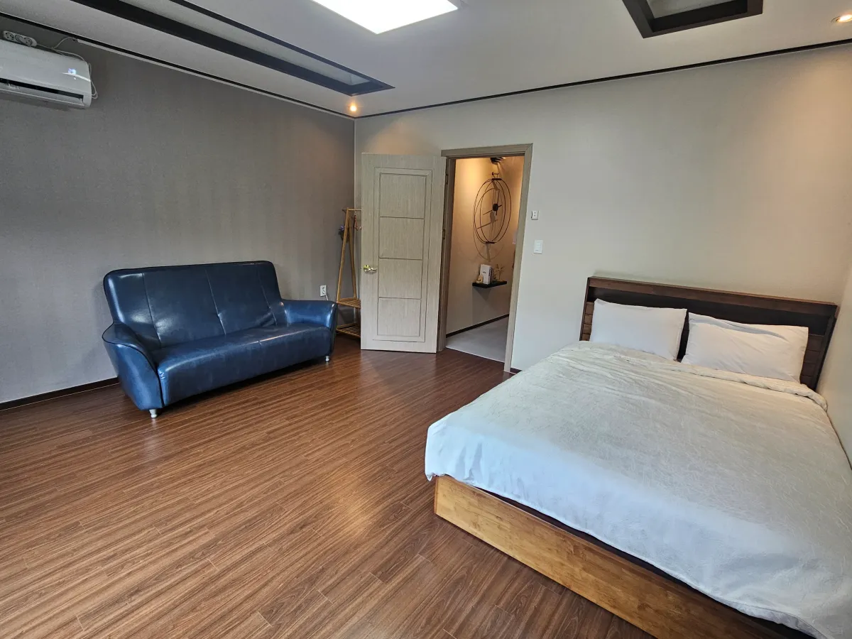 퀸사이즈-침대와-파란색-소파가-있는-방