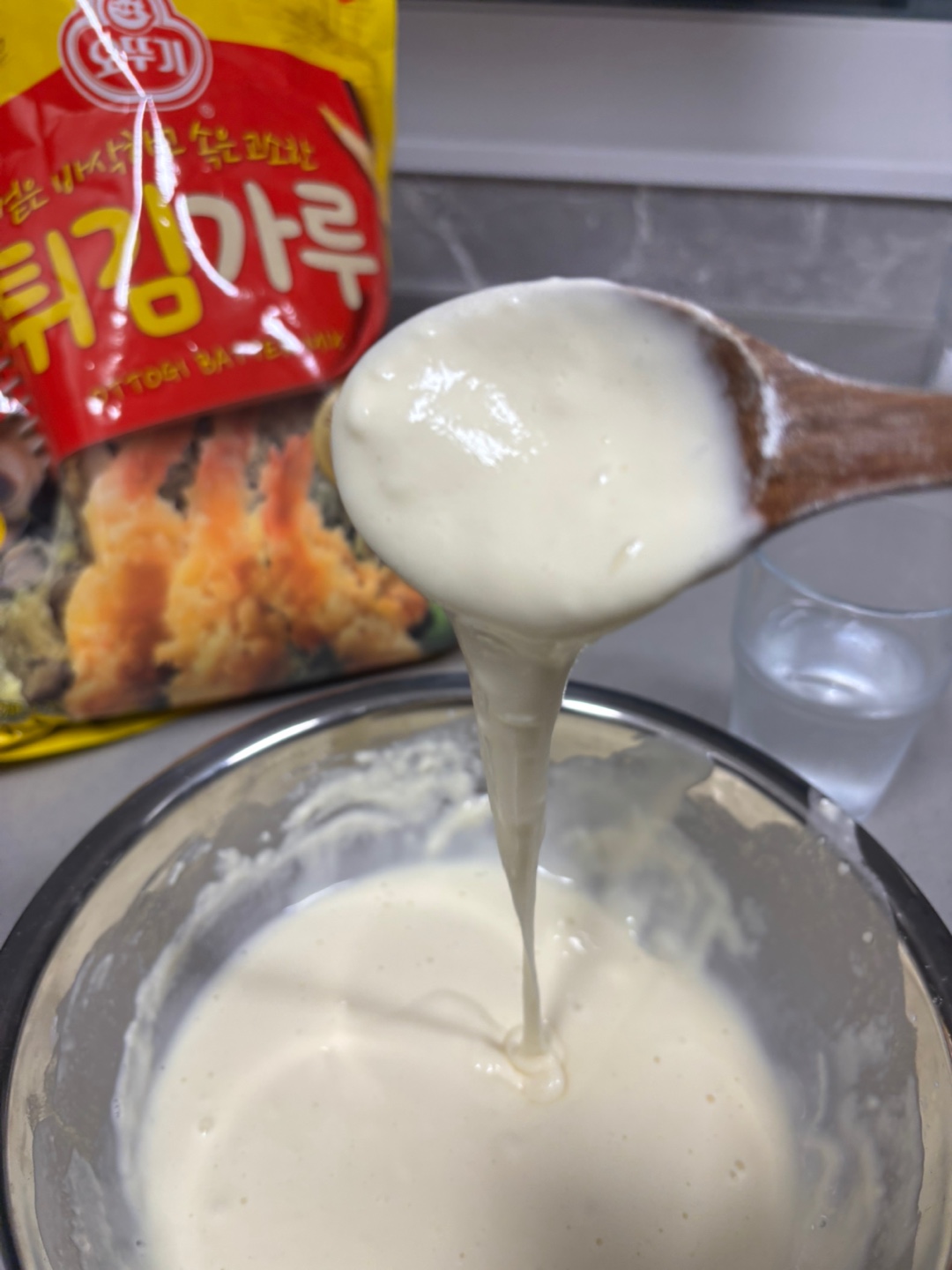 튀김가루가 볼 안에 반죽 되어 있고 숟가락으로 반죽 농도가 보인다