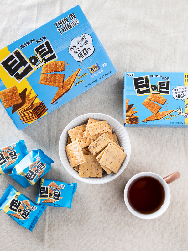 하늘색 케이스에 들어있는 과자, 커피, 하얀 접시에 담아둔 크래커