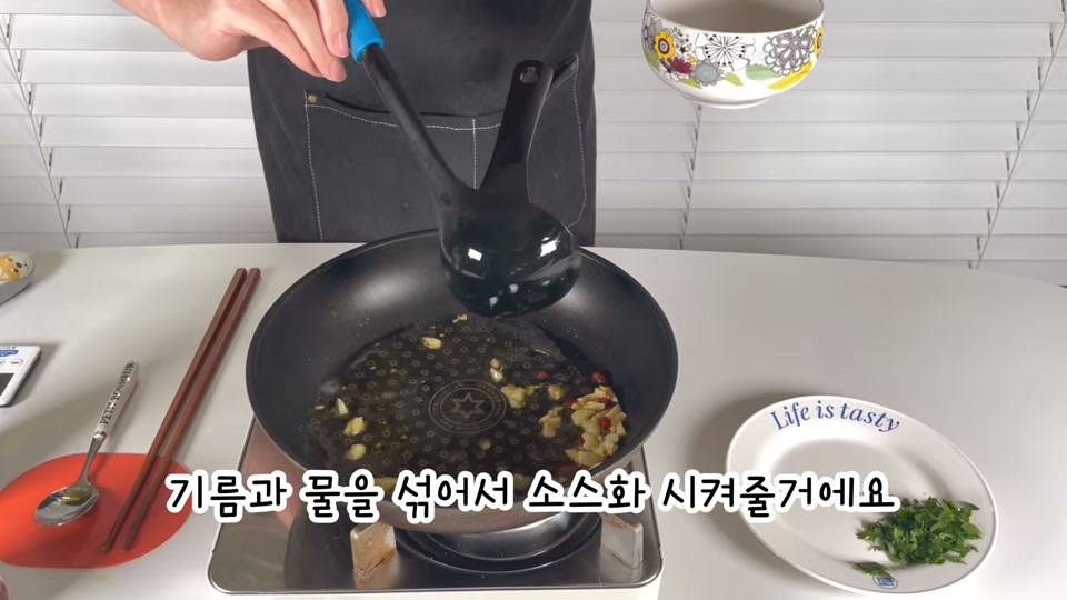 국자로 기름과 면수를 섞는 장면