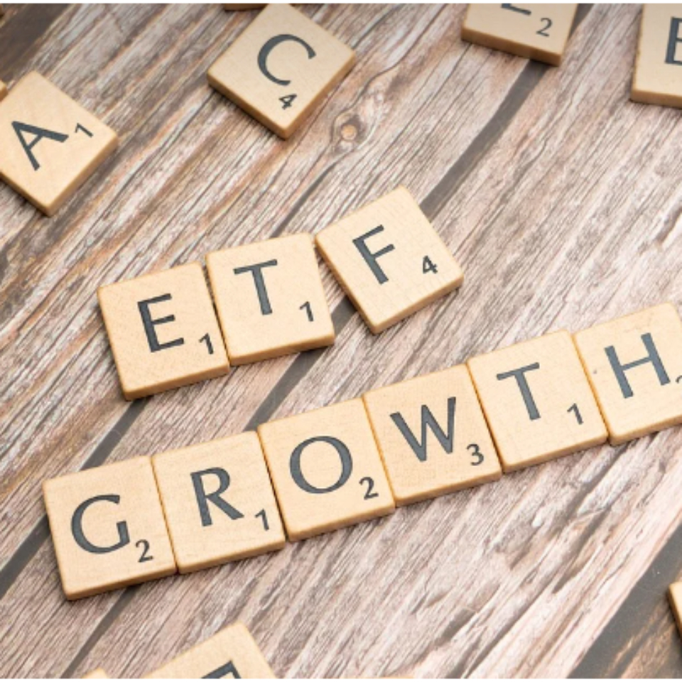 나무 블록으로 ETF 글자를 만들었고 주변에 다른 알파벳 나무 블록들이 흩어져있음