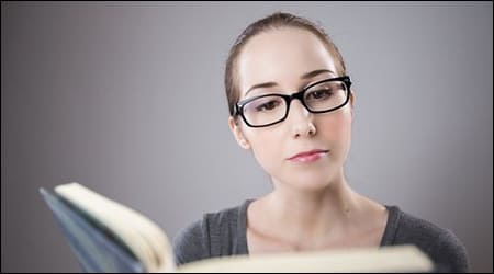 안경을 끼고 책을 읽는 여성