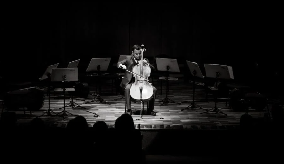 무대에서 첼로 연주하는 남자 사진