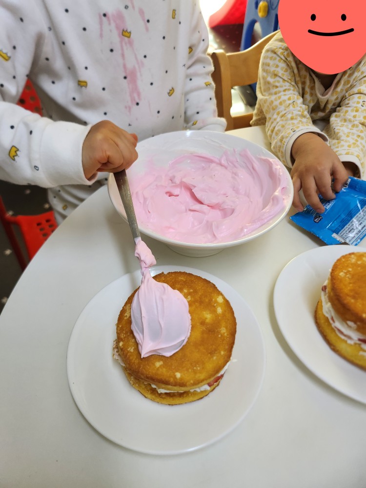 분홍색 크림을 빵 겉면에 바르는 아이
