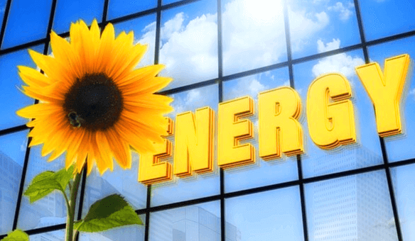 투명 유리창에 비친 파란 하늘과 하얀 구름 그리고 그 앞에 놓인 노란 해바라기와 영문자로 에너지라고 쓰여있다.