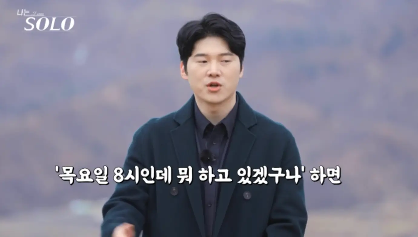 나는 솔로-숲배경 검은 코트를 입고 얘기하는 영식 아래 흰색글씨 목요일 8시인데 뭐 하고 있겠구나'하면