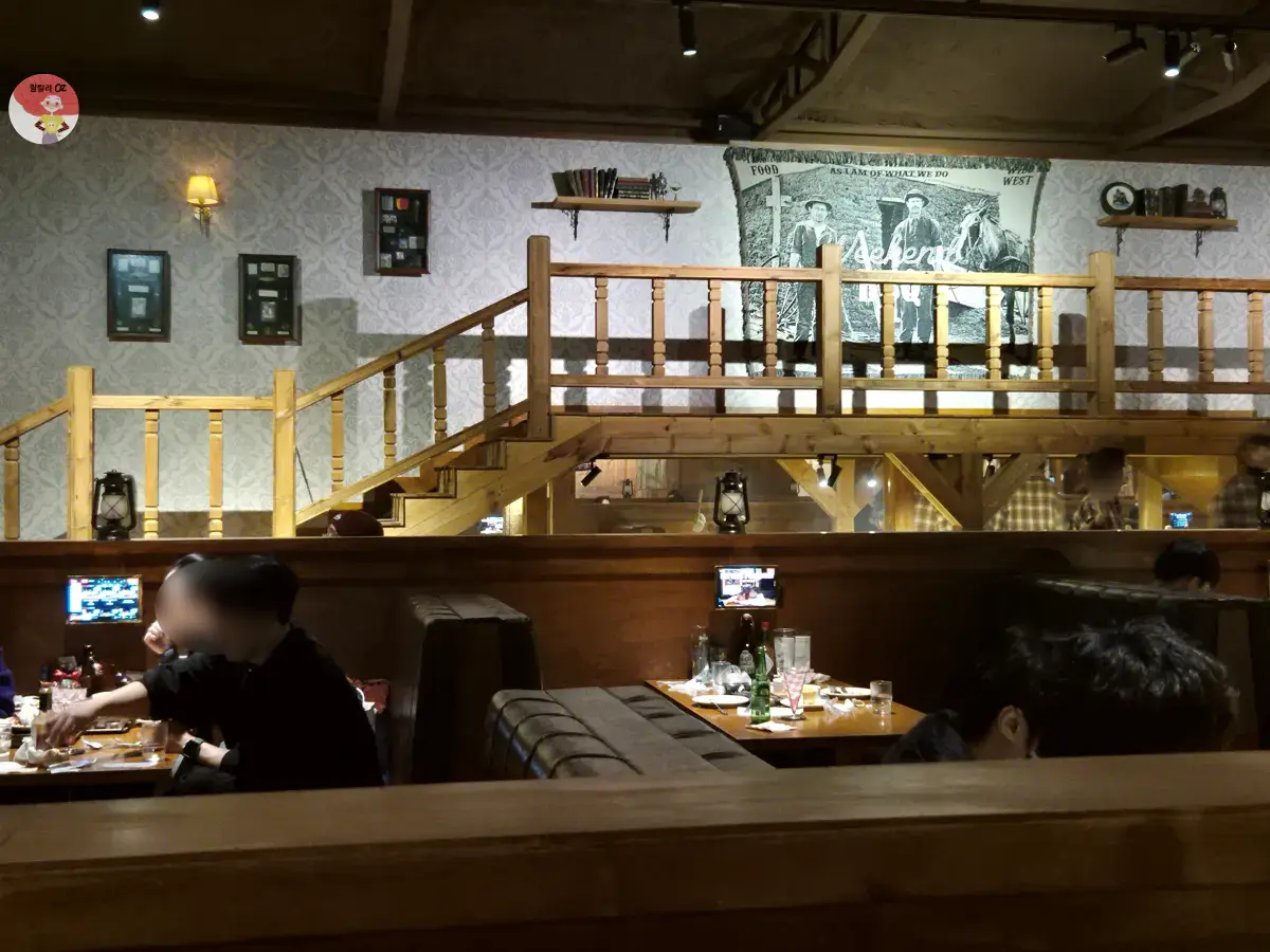 경기-위켄드-바베큐-남양주-다산본점-내부-인테리어-서부-벽화가-걸린-벽과-원목-계단