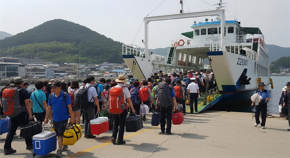 주말에 배를 기다리는 여행객이 많은 선착장 장면 