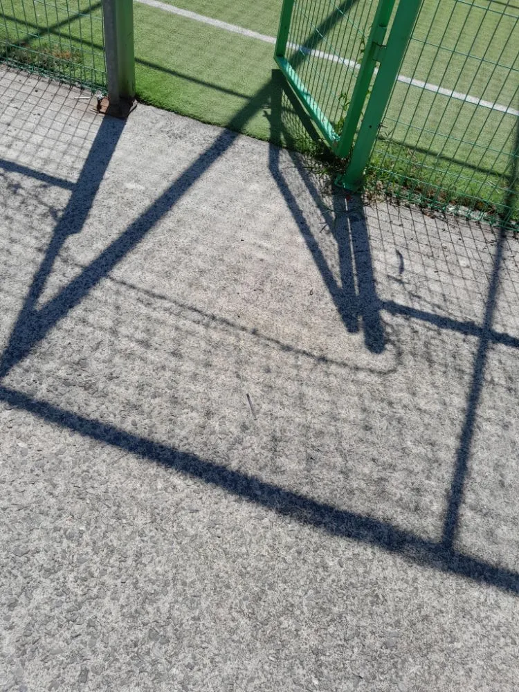 굳게 닫힌 철제문이 콘크리트 바닥에 드리운 짙은 그림자.