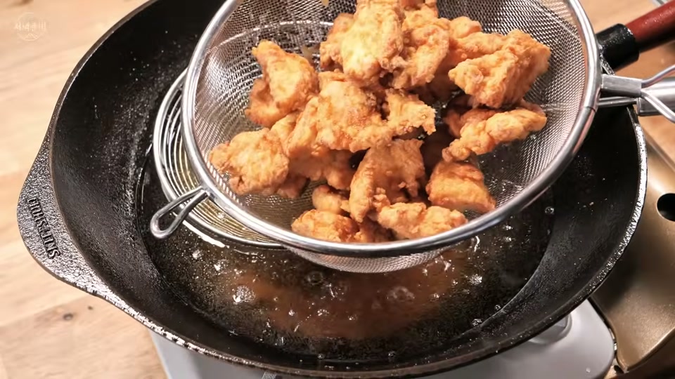 체에 밭쳐 기름을 빼는 장면