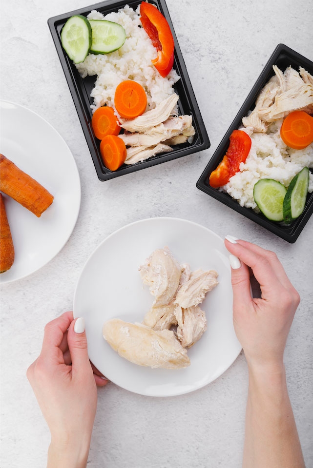 소분된 밥과 다양한 야채 닭가슴살 고기를 여러 개의 도시락 용기에 담아 놓은 이미지
