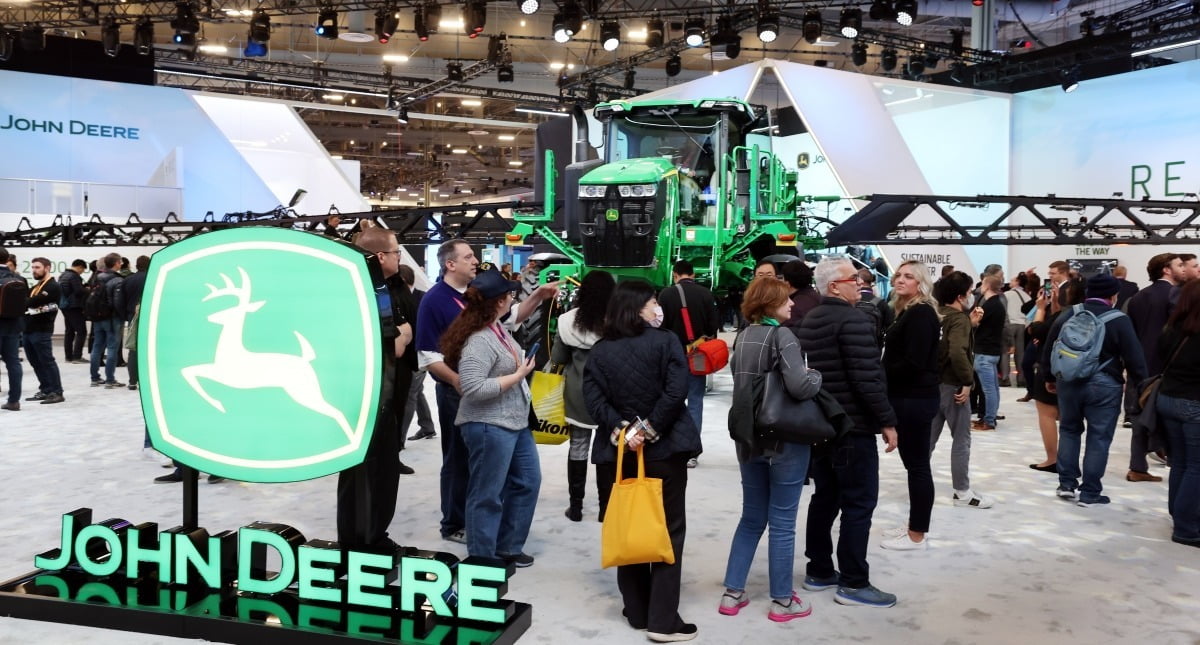 CES 2023의 존디어 전시관에서 관람객들이 자율주행 트랙터 및 센서 인공지능(AI) 기술 등을 이용한 해충 자동 박멸 기술을 살펴보고 있다.
