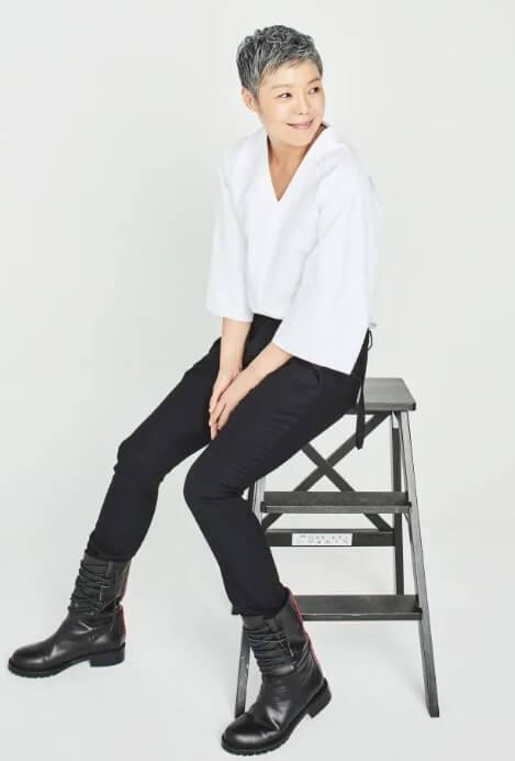 이은미가-검은-바지와-흰-셔츠를-입고-사다리형-의자에-앉아-있는-사진