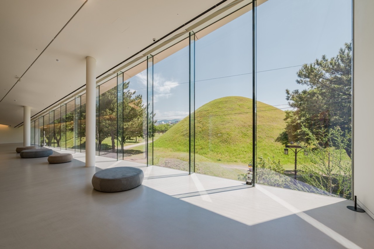 현대적인 건축물의 프레임 사이로 경주의 부드러운 왕릉 능선이 한 폭의 그림처럼 담긴 모습